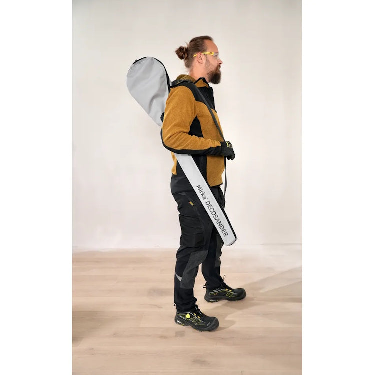 Worker carrying Mirka DecoSander in its shoulder carrying case — lightweight portable sander kit