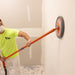 Contractor using Radius360 Dust-Free Conversion Kit and pole to sand drywall wall with vacuum