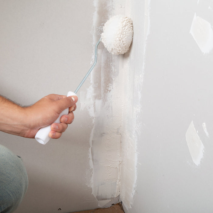 Renegade Drywall compound roller applying joint compound over taped seam for smooth finishing