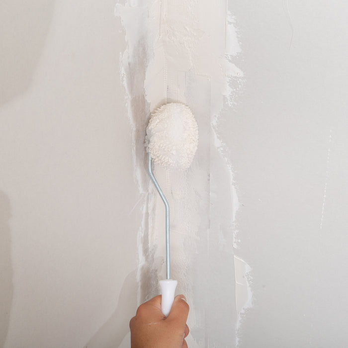 Renegade Drywall compound roller applying joint compound over taped drywall seam