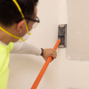Contractor using Flex Edge 2.0 vertically on wall to smooth joint lines, reach tight angles and outlets cleanly