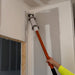 Worker using MudRunner Pro’s applicator head and handle to apply compound in drywall corner